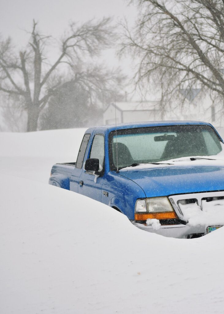A blue pickup truck buried in snow during a severe winter storm in Lusk, Wyoming.
